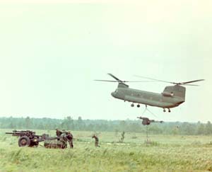 CH-47 CHINOOK DELIVERING 105-MM HOWITZER (TOWED) WITH AMMUNITION PALLET