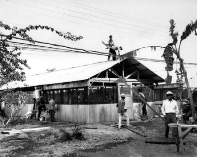 PICTURE - VIETNAMESE CONSTRUCTION WORKERS erect a tropicalized hut at Tan Son Nhut.