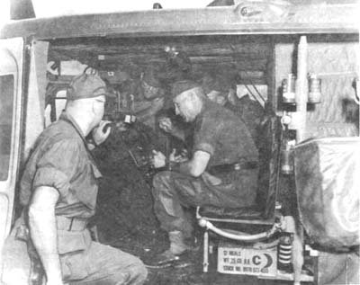 Photograph: General Van Harlingen (seated) Inspects Communications Gear On A Command Helicopter