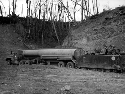 Picture - Armored Personnel Carrier Gives 5,000-Gallon Tanker Push Up Muddy Hill To Fire Support Base