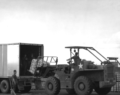 Picture - Fork Lift Unloading Pallets of 105mm Howitzer Rounds From a Sea-Land Van, Pleiku, Vietnam