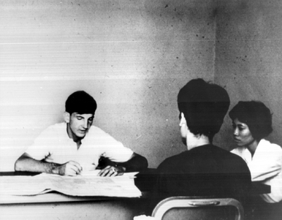 Photo: A QUALIFIED U.S. INTERROGATOR WHO CANNOT SPEAR VIETNAMESE questions a .source with the help of a Vietnamese WAC interpreter.
