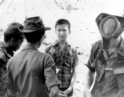 Photo:  VIET CONG SUSPECT being questioned by Vietnamese police officers of the Combined Intelligence Staff.
