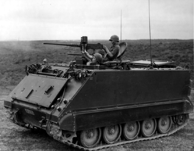 PICTURE - ARMORED PERSONNEL CARRIER, M113, firing .50-caliber machine gun during South Vietnamese training exercise. Barrel of side-mounted .30-caliber machine gun can be seen on far side of M113.
