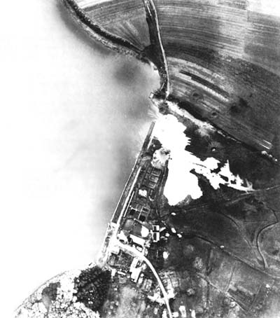 Photograph: Bombing Of Etang De Lindre Dam by P-47s on 20 October. The photograph was made fifteen seconds after the dam was breached.