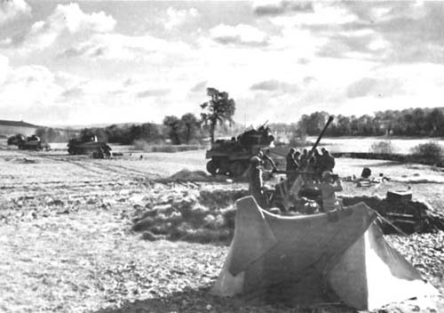 Photograph: Tanks Awaiting Signal To Cross Moselle, as 712th Tank Battalion near Sentzich moves up to support 90th Infantry Division. Antiaircraft gun is shown in foreground.