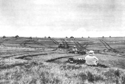 Photograph: Tanks and Armored Infantry of CCA starting out to aid CCB in the fight for Hill P8 north of Mackwiller.