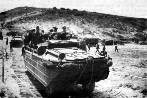 VISITORS AT NORMANDY BEACHHEAD, 12 June 1944. Holding the rail in the DUKW are General Marshall, General Eisenhower, and Admiral King.