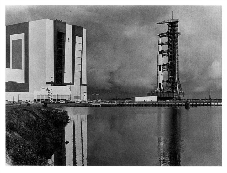 view of the rocket assembly building and a  massive Saturn rocket on  transport